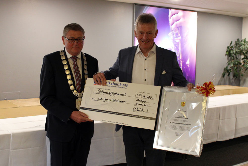 Den mit 1.500 Euro dotierten Ehrenamtspreis der Stadt Dinklage erhielt nun Dr. Jürgen Hörstmann (rechts). Bürgermeister Carl Heinz Putthoff überreichte die Urkunde unter dem Applaus der anwesenden Gäste. (Foto: Dödtmann / Stadt Dinklage.)